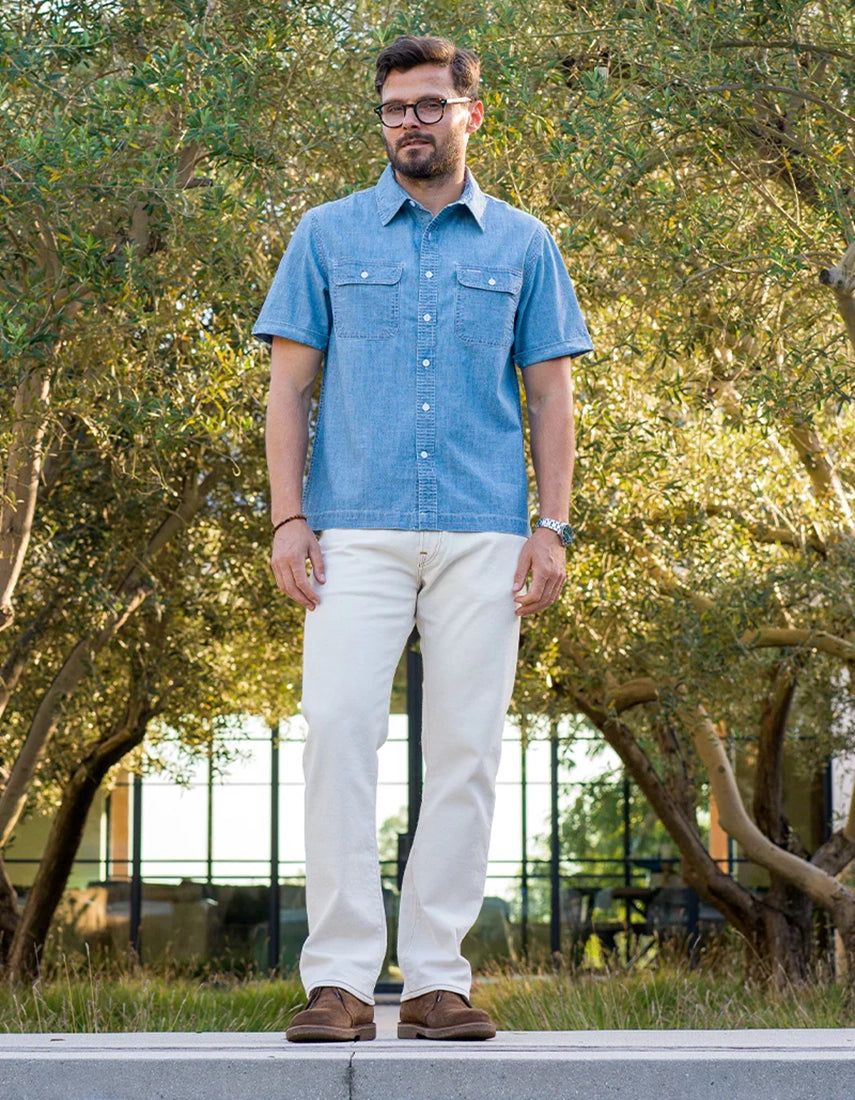 Man wearing Ace Rivington indigo chambray short sleeve shirt with cream pants outdoors