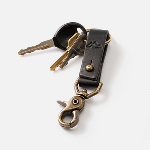 Black leather keychain with brass hardware clipped to keys