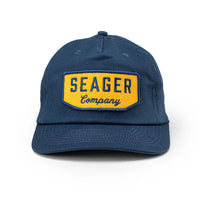 Front-facing view of navy Seager Wilson Snapback Hat with yellow embroidered patch