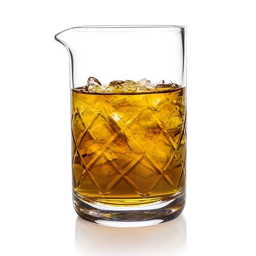 Clear glass filled with amber liquid and ice cubes on a white background