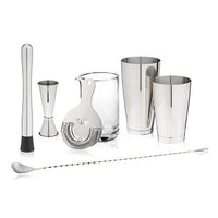 Set of cocktail-making tools including jiggers, shaker, and strainer on a white background