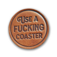 Leather coaster with "Use a Fucking Coaster" stamped on it