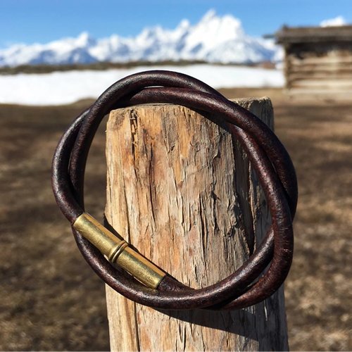 Tres Cuervos Flint double wrap Bracelet with .22 shell magnetic closer in Brown leather, stylized on a fence post
