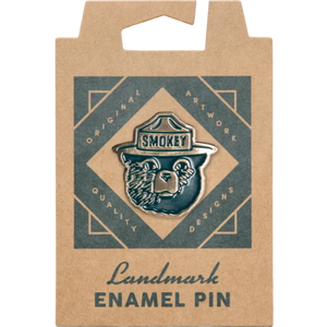 Smokey Bear enamel pin mounted on an illustrated kraft backing card